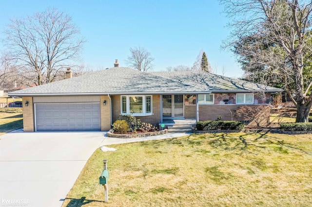 single story home with driveway, brick siding, a garage, and a front yard