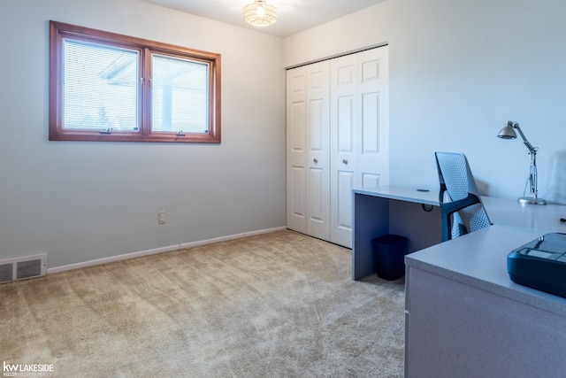 unfurnished office featuring carpet, visible vents, and baseboards