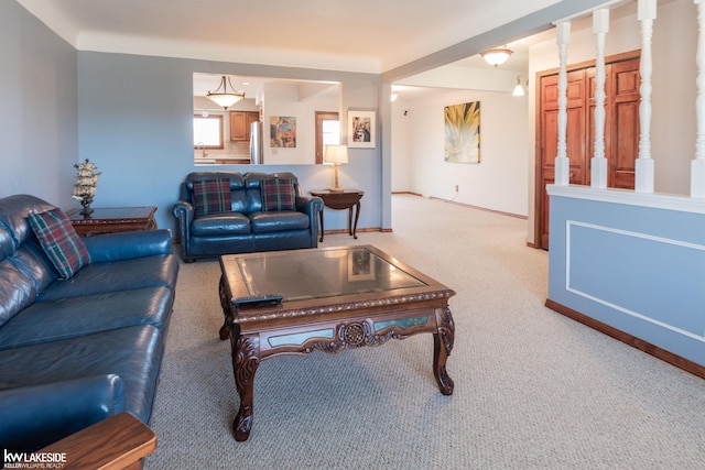 carpeted living area featuring baseboards