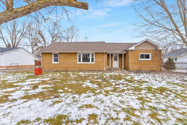 view of front of house featuring fence and brick siding