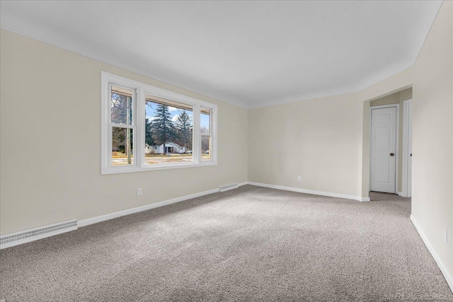 empty room featuring carpet, visible vents, and baseboards