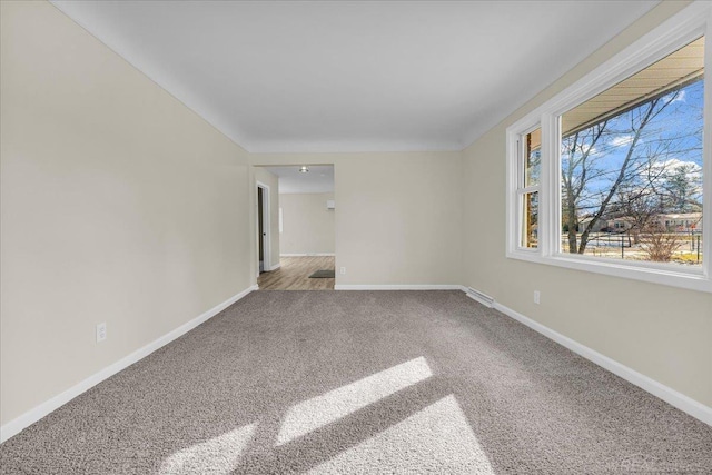 carpeted empty room with visible vents and baseboards