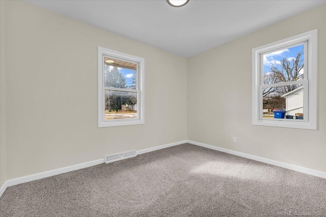 carpeted empty room with visible vents and baseboards