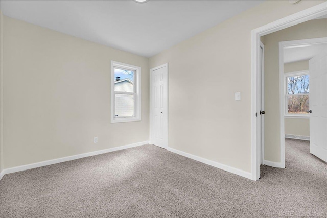 carpeted spare room with plenty of natural light and baseboards