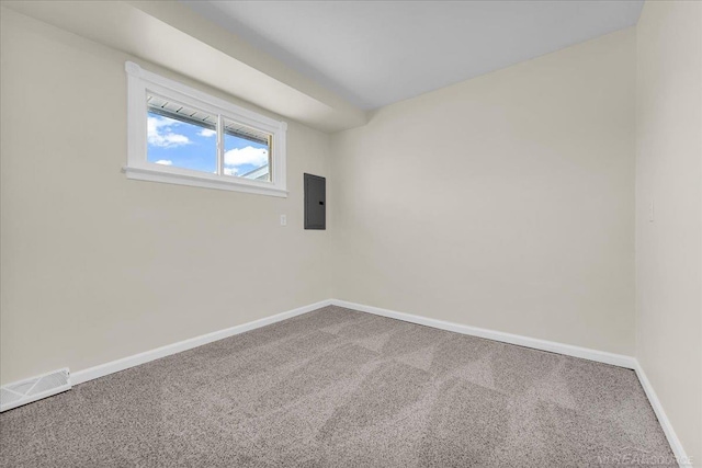 empty room featuring carpet floors, visible vents, electric panel, and baseboards