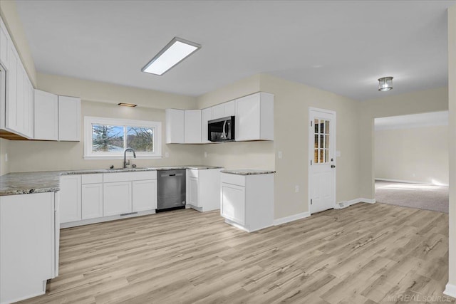 kitchen with light wood-style floors, white cabinets, a sink, and stainless steel dishwasher