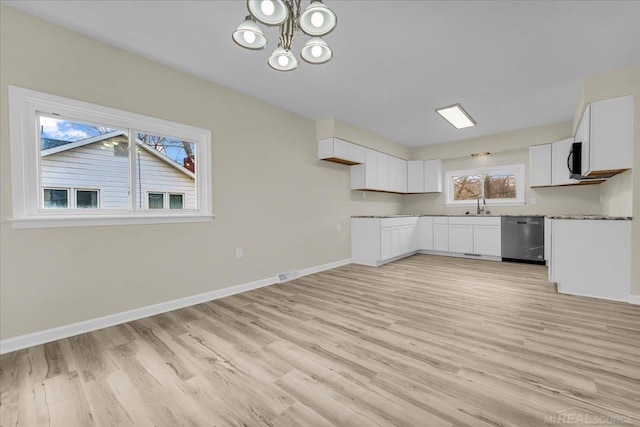 kitchen featuring light wood finished floors, white cabinetry, baseboards, and stainless steel dishwasher