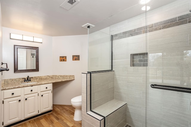 25540 Waterview Dr, Harrison Twp, MI 48045 - full bathroom with vanity, toilet, wood finished floors, visible vents, and tiled shower