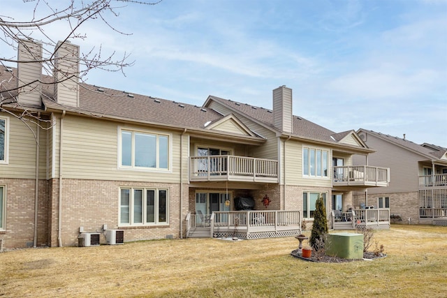 25540 Waterview Dr, Harrison Twp, MI 48045 - rear view of property with a balcony, a chimney, brick siding, central AC unit, and a lawn