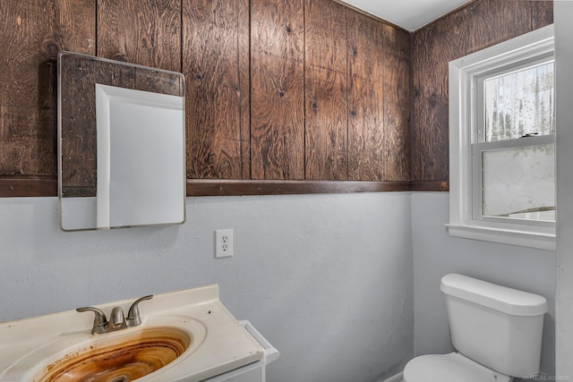 half bathroom featuring vanity and toilet