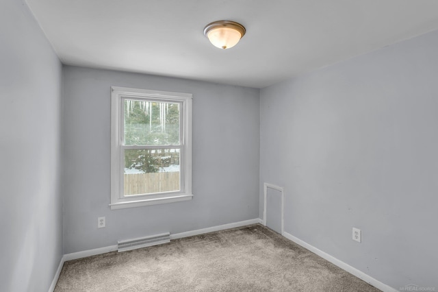 spare room with carpet, visible vents, and baseboards