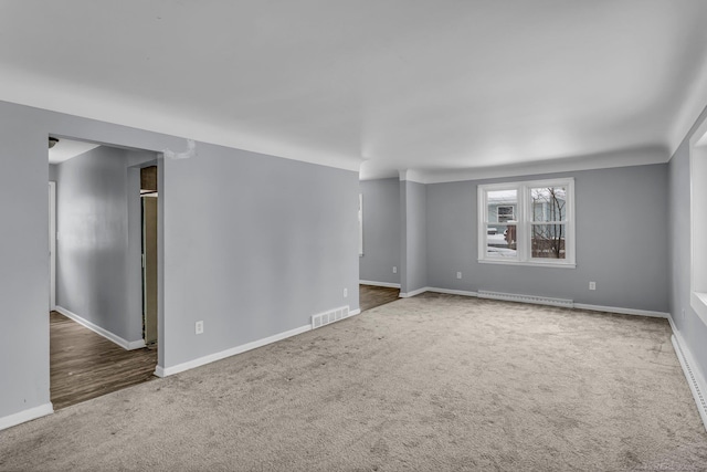 carpeted spare room featuring baseboards and visible vents