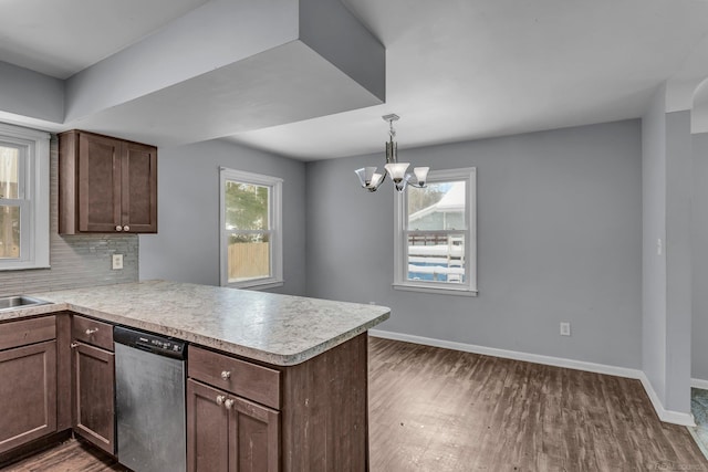 kitchen featuring baseboards, dark wood finished floors, a peninsula, and stainless steel dishwasher