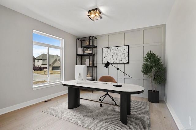 office with baseboards, visible vents, and light wood-style floors