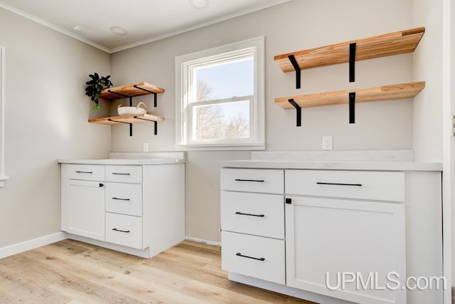 interior space with ornamental molding, baseboards, and light wood finished floors