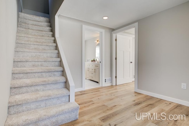 stairs featuring recessed lighting, visible vents, baseboards, and wood finished floors