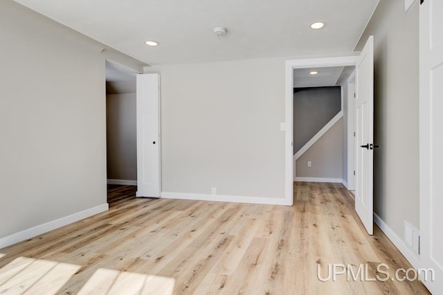 spare room with recessed lighting, baseboards, and wood finished floors