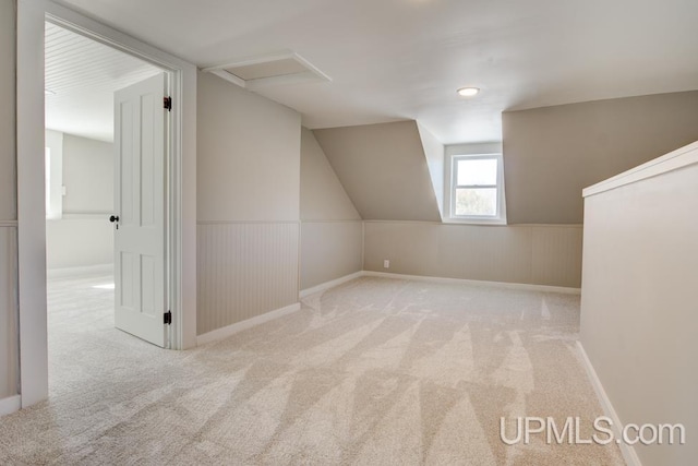 bonus room featuring attic access, carpet, and a wainscoted wall