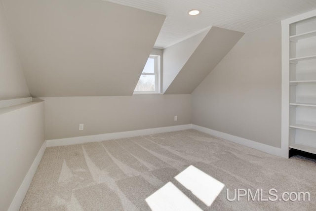 additional living space featuring recessed lighting, built in features, vaulted ceiling, baseboards, and carpet