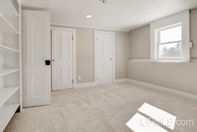 unfurnished bedroom featuring carpet and baseboards