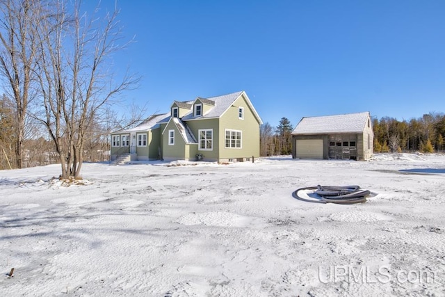 view of front of house with a garage and an outbuilding