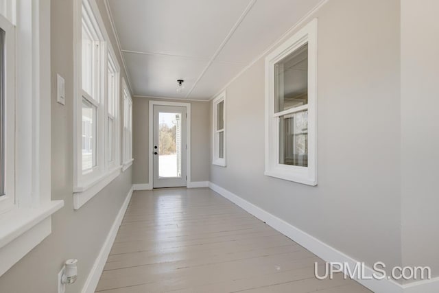 doorway to outside featuring baseboards and hardwood / wood-style floors