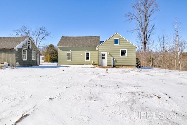 view of snow covered rear of property