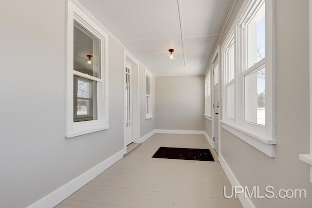 entryway featuring baseboards and wood finished floors