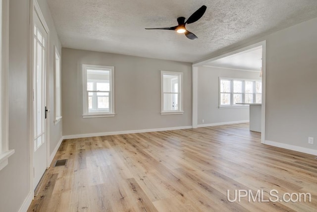 empty room featuring light wood-style floors, visible vents, and a textured ceiling