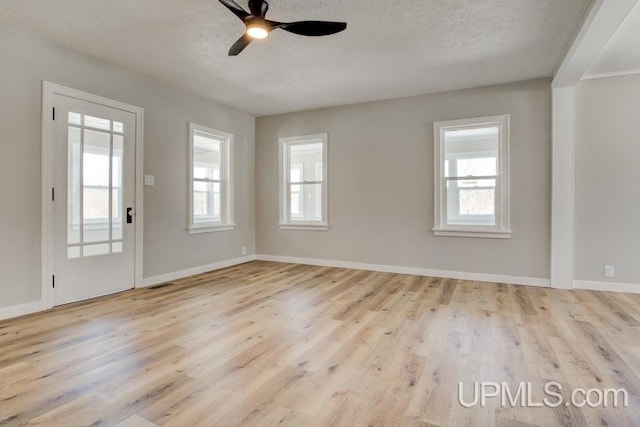 unfurnished room with a textured ceiling, wood finished floors, and visible vents