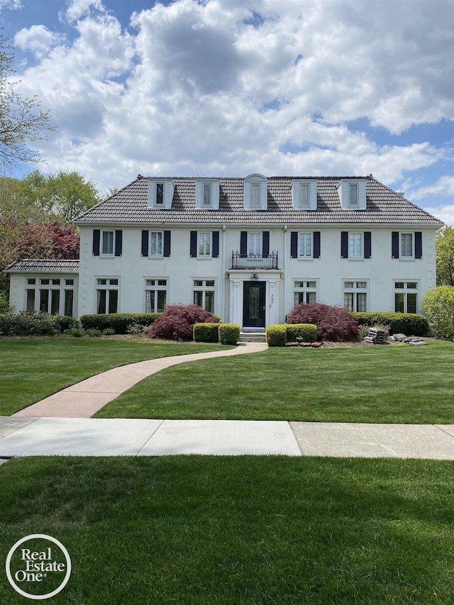 view of front of home with a front yard and a tile roof