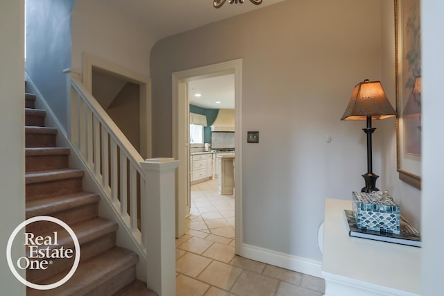 staircase featuring baseboards and tile patterned floors