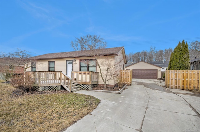 view of front of property with a garage, an outbuilding, and fence