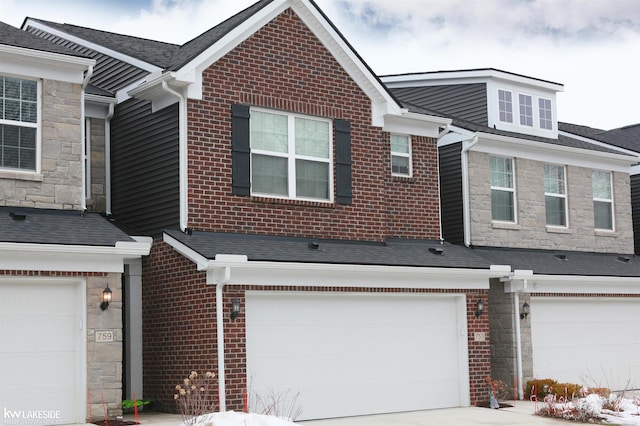 view of property with stone siding, brick siding, and an attached garage