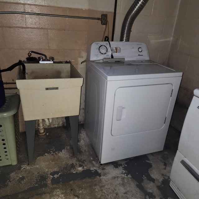 clothes washing area featuring washer / clothes dryer and a sink