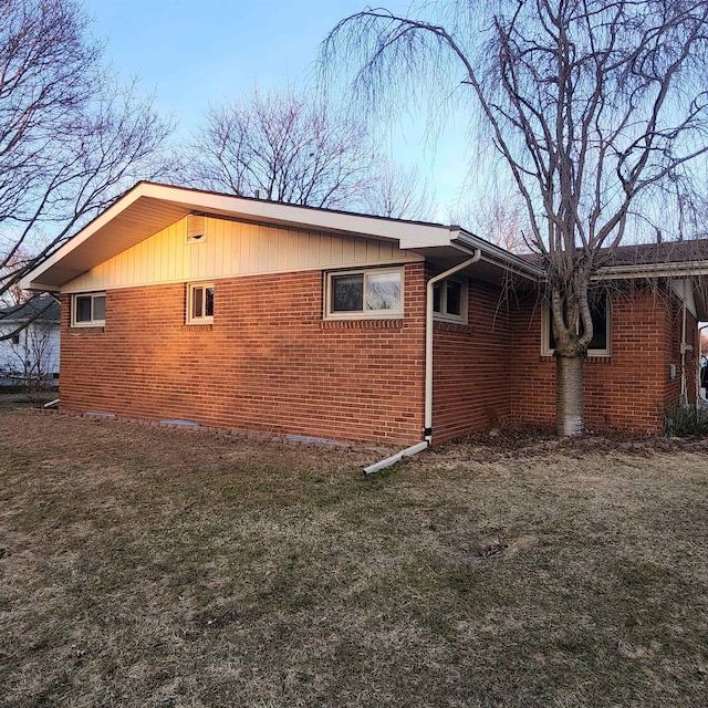 view of home's exterior featuring a yard and brick siding