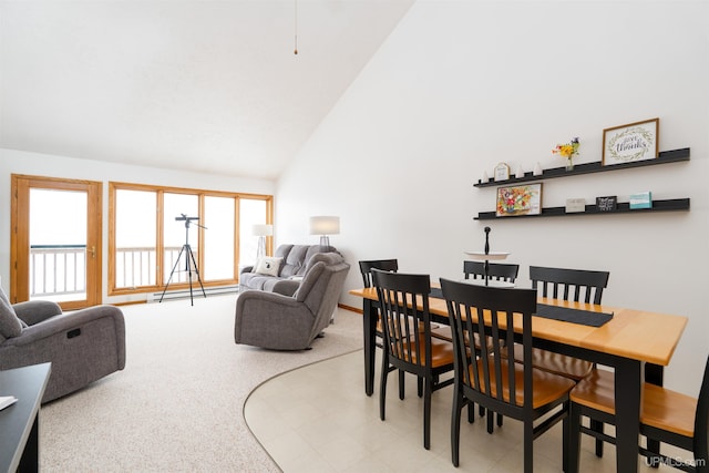 dining area with a baseboard radiator, high vaulted ceiling, and light colored carpet