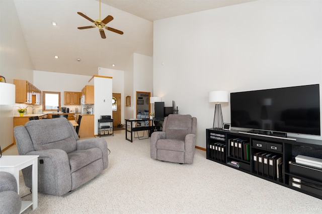 living area featuring ceiling fan, high vaulted ceiling, baseboards, and light colored carpet