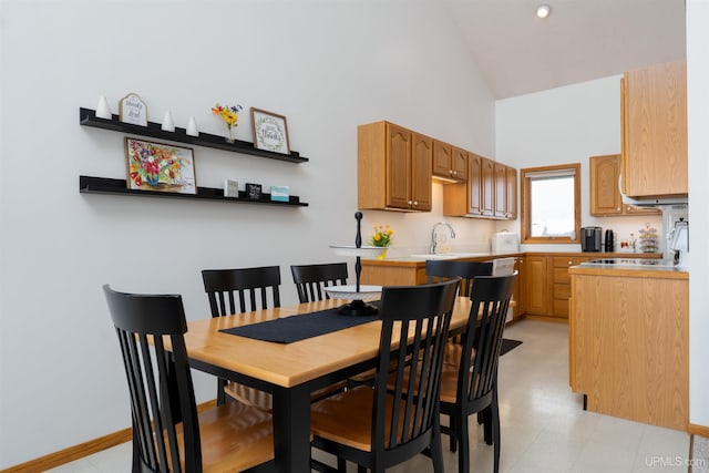 dining area with high vaulted ceiling and baseboards