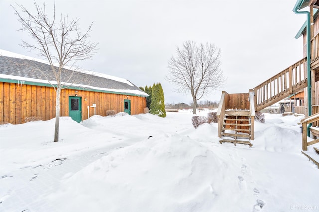 yard layered in snow featuring stairs