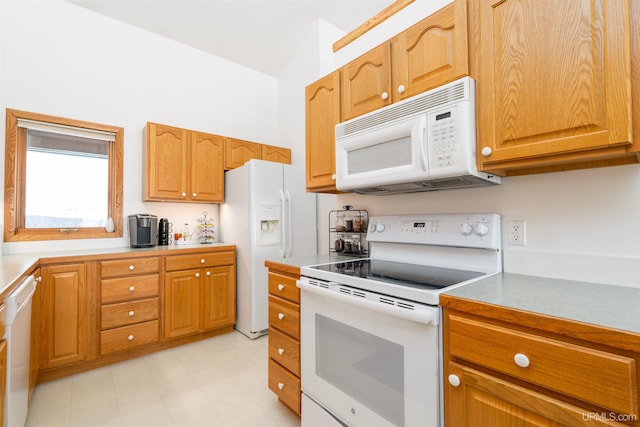 kitchen featuring brown cabinets, white appliances, light countertops, and light floors