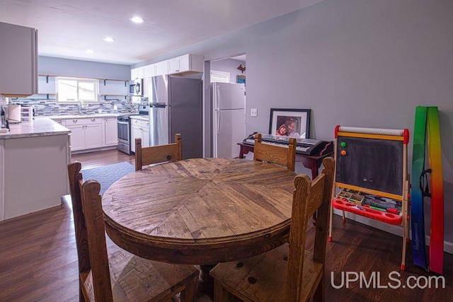 dining space featuring dark wood-type flooring and recessed lighting