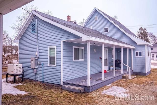 back of property featuring covered porch