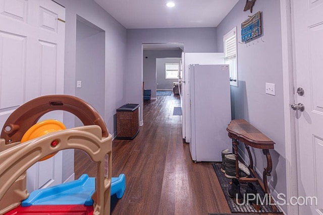 hall featuring dark wood-type flooring and baseboards