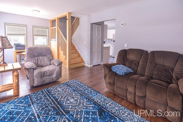 living room with stairway, wood finished floors, and baseboards