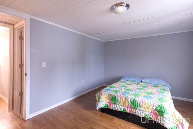 bedroom featuring ornamental molding, wooden ceiling, wood finished floors, and baseboards