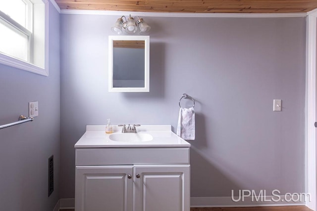 bathroom featuring visible vents, ornamental molding, and vanity