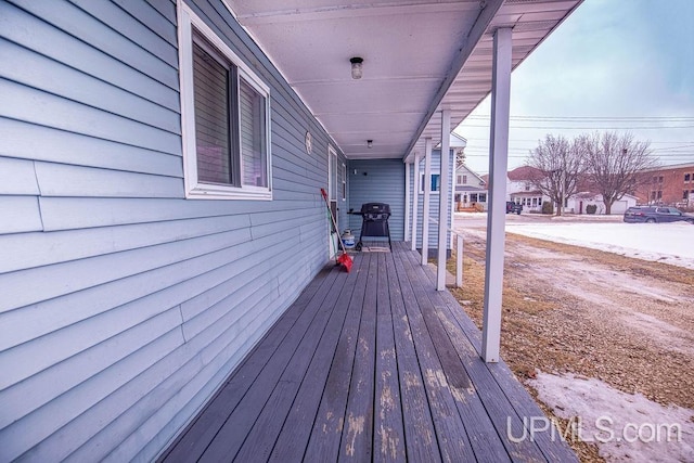 wooden deck with a residential view and a grill