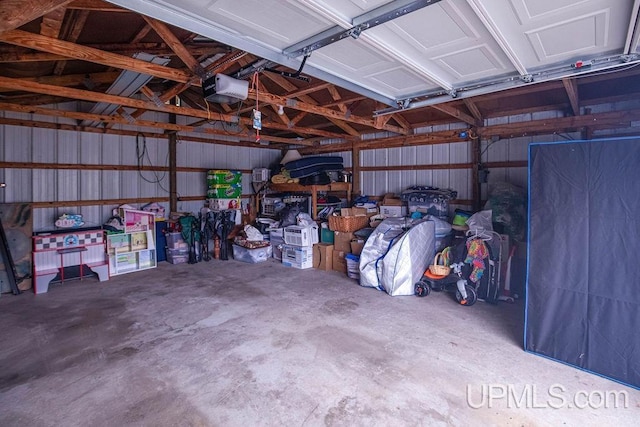 garage with a garage door opener and metal wall