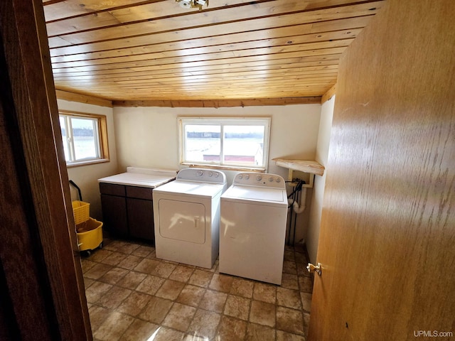 laundry area featuring cabinet space, wooden ceiling, and separate washer and dryer